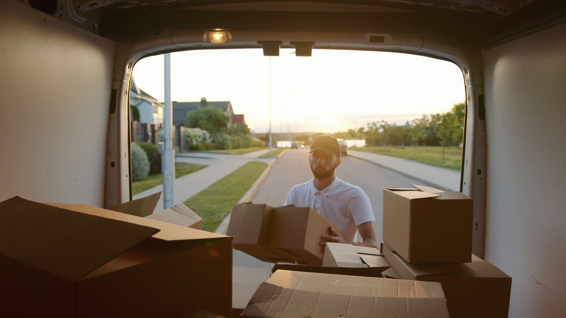 Person loading cardboard boxes into a van.